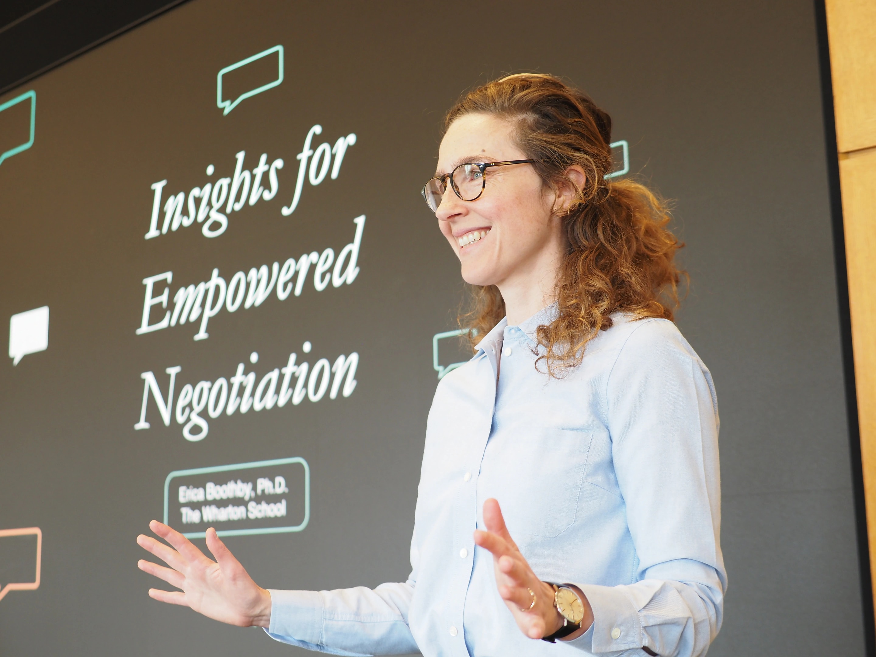 Erica Boothby presenting in front of a negotiation slide
