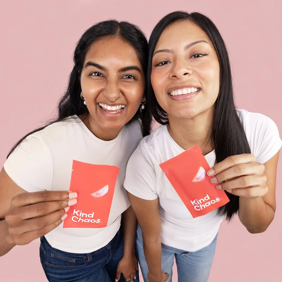 Kind Chaos: two women smiling and holding the brand's pouches