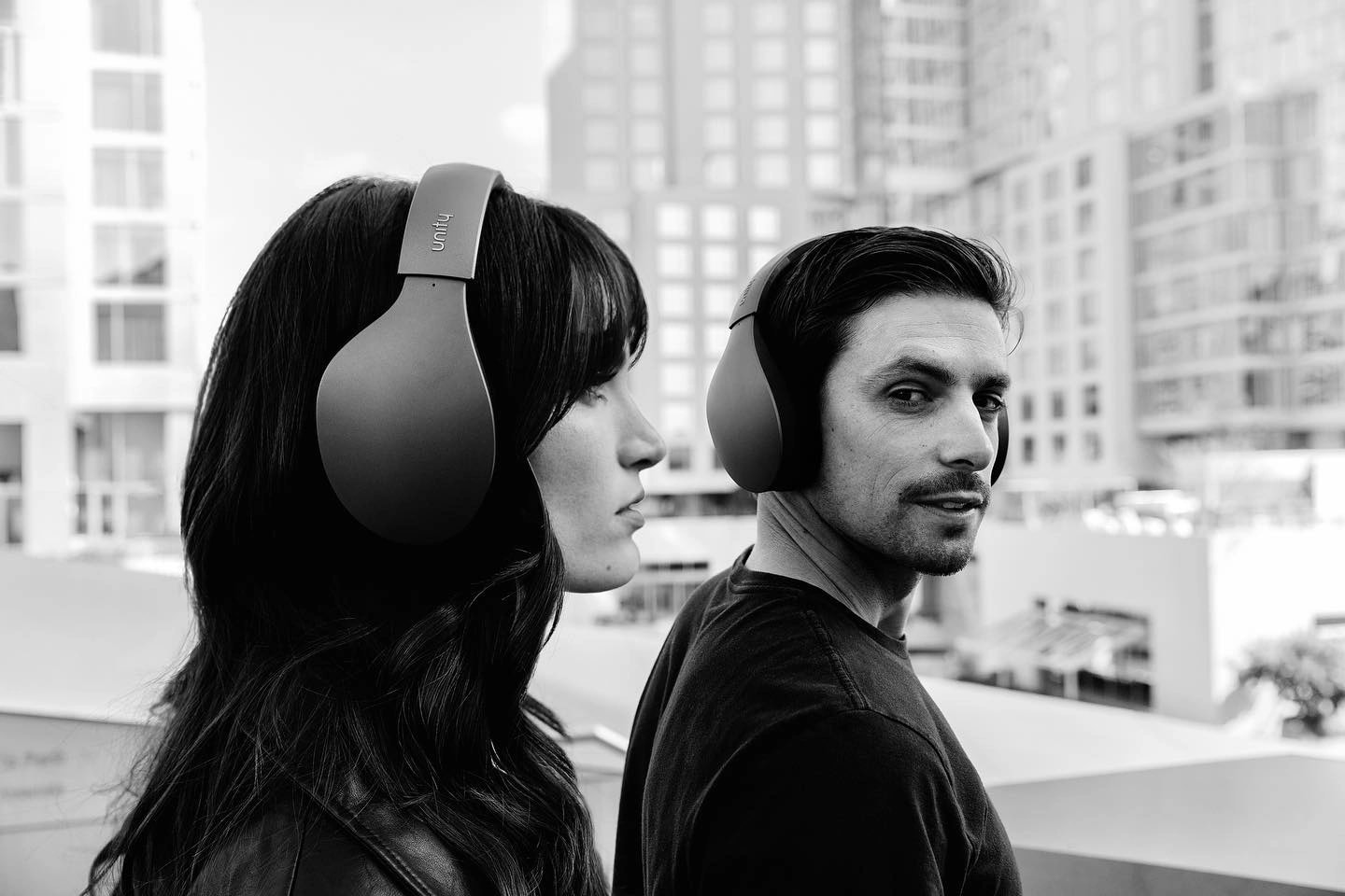Unity: two people wearing the headphones outdoors, in black and white